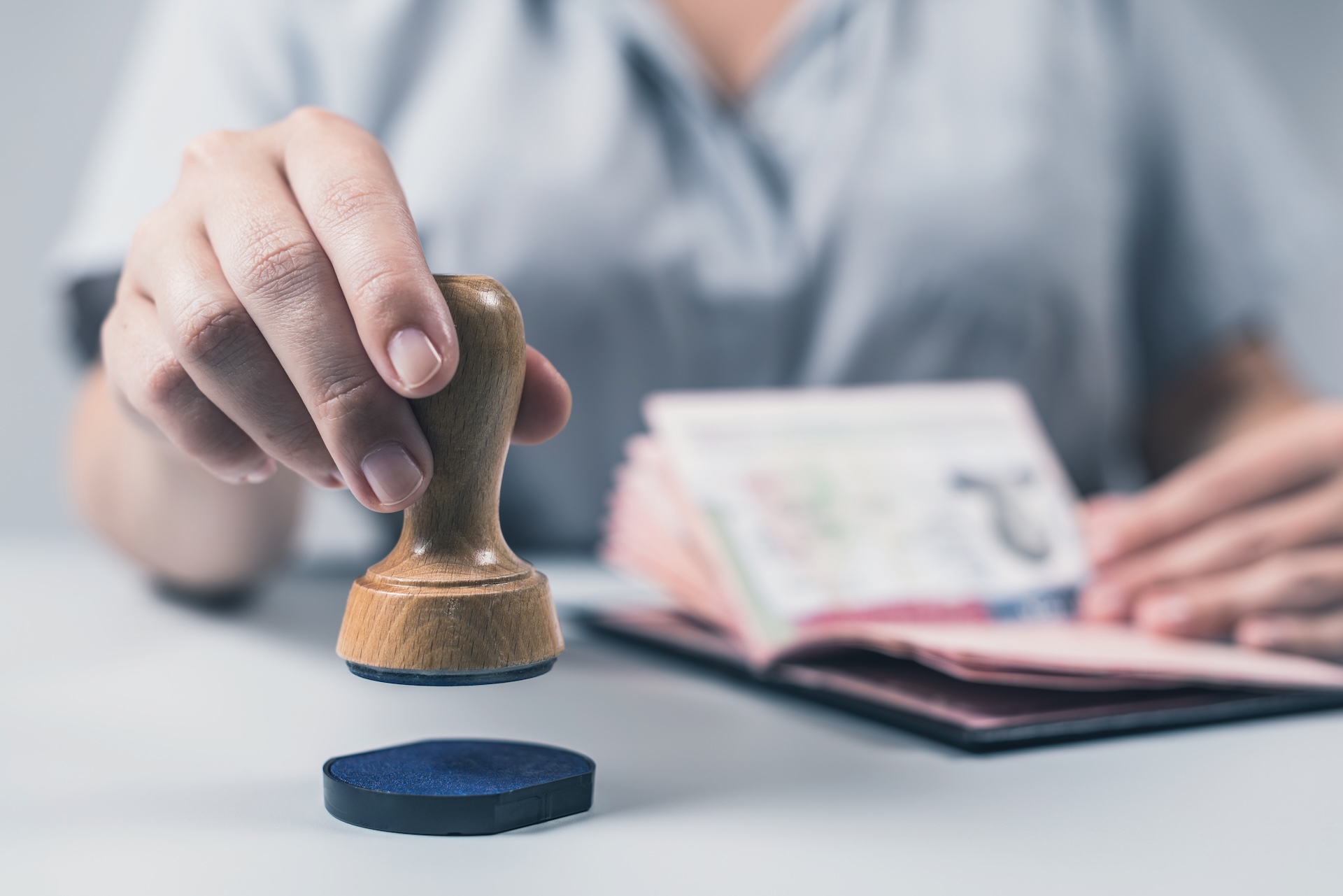 Immigration and passport control at the airport. woman border control officer puts a stamp in the US passport of american citizen. Concept Immigration and passport control at the airport. woman border control officer puts a stamp in the US passport of american citizen.
